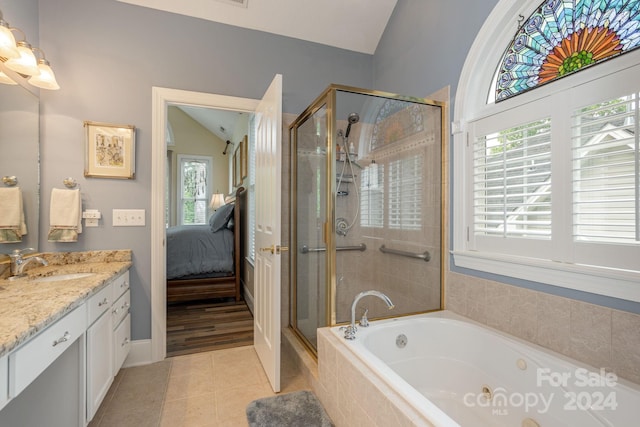 bathroom featuring vanity, tile flooring, lofted ceiling, and plus walk in shower