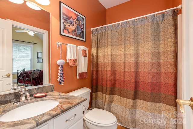 bathroom featuring ceiling fan, toilet, and vanity