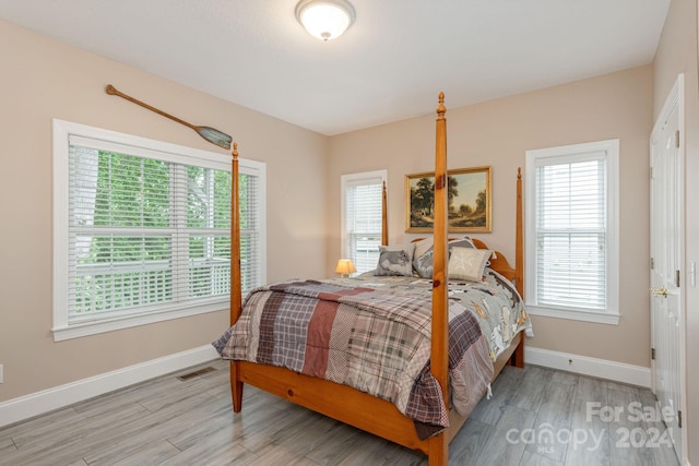 bedroom with hardwood / wood-style flooring and multiple windows