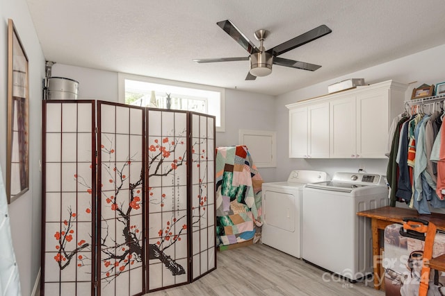 washroom with ceiling fan, washing machine and clothes dryer, a textured ceiling, and light wood-type flooring