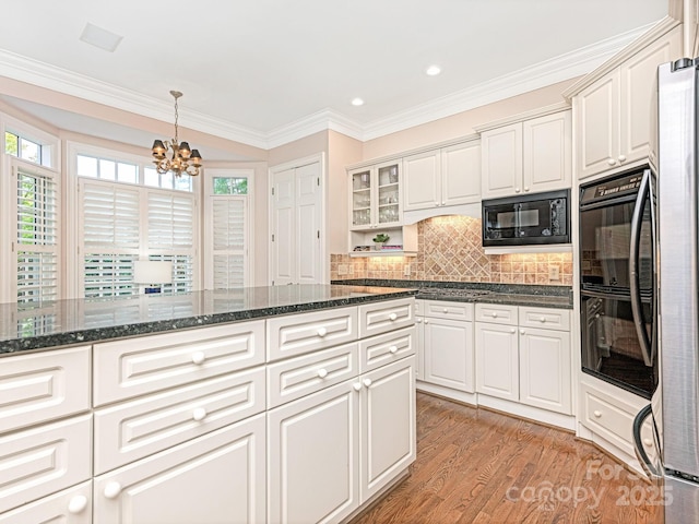 kitchen featuring white cabinetry, pendant lighting, tasteful backsplash, and black appliances