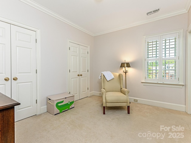 sitting room featuring ornamental molding and light colored carpet