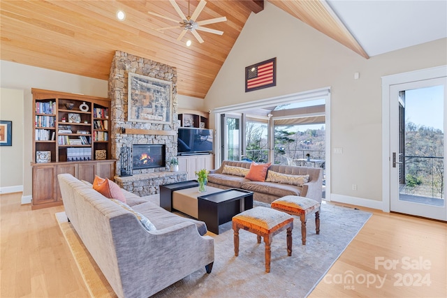 living room featuring a stone fireplace, ceiling fan, light wood-type flooring, wood ceiling, and high vaulted ceiling