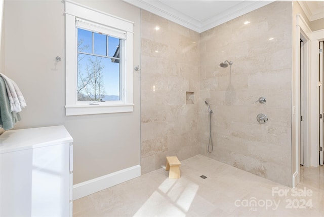 bathroom with tile floors, tiled shower, and crown molding