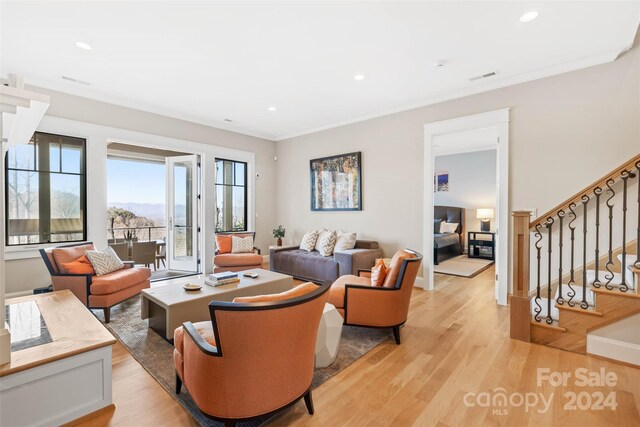 living room featuring ornamental molding and light wood-type flooring