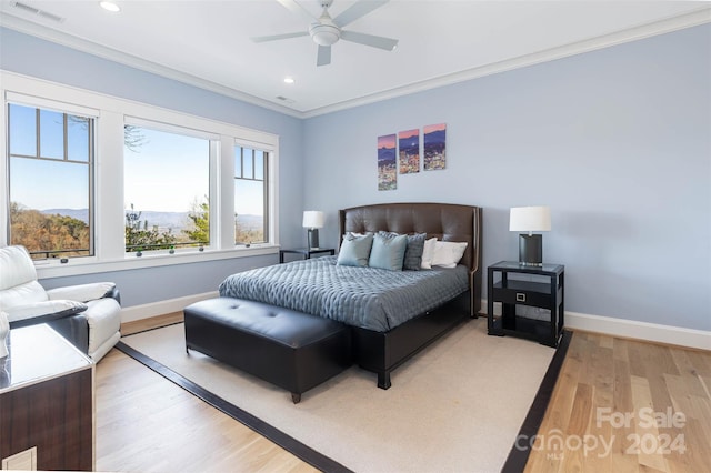 bedroom featuring light hardwood / wood-style floors, ornamental molding, and ceiling fan