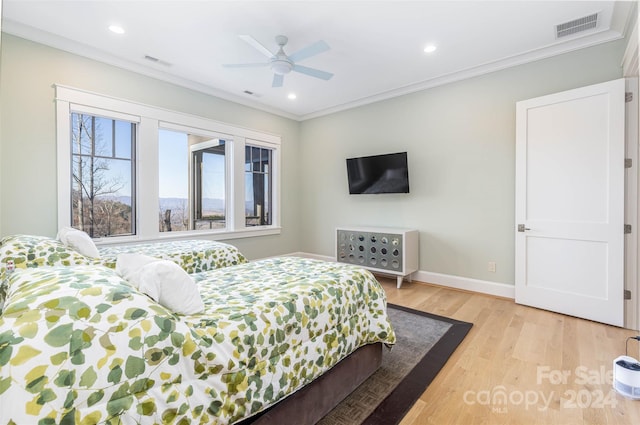 bedroom with ceiling fan, light hardwood / wood-style flooring, and crown molding