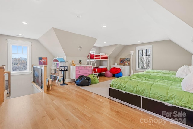 bedroom with light wood-type flooring and lofted ceiling