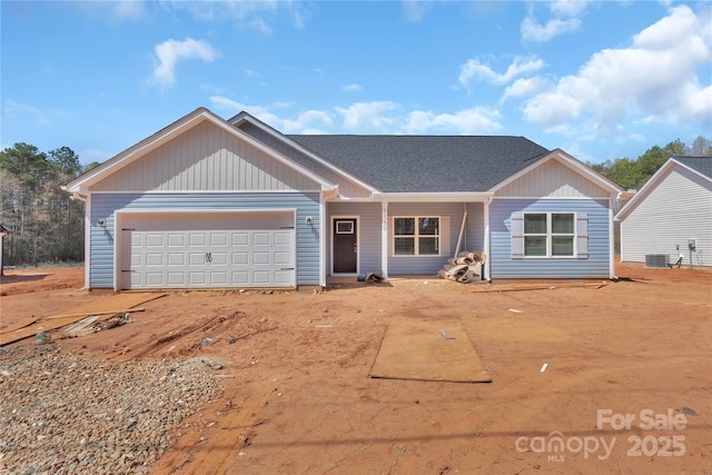 single story home with cooling unit and a garage