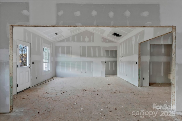 unfurnished living room featuring vaulted ceiling