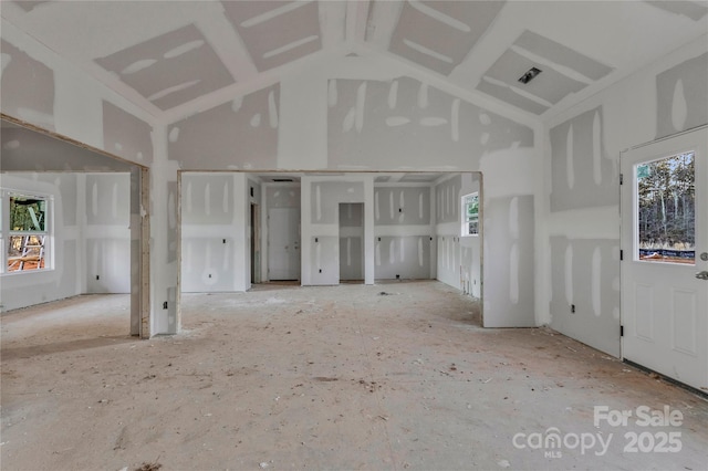 unfurnished living room with a high ceiling and a healthy amount of sunlight