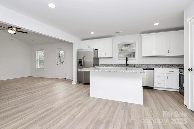 kitchen featuring appliances with stainless steel finishes, a center island, and white cabinets