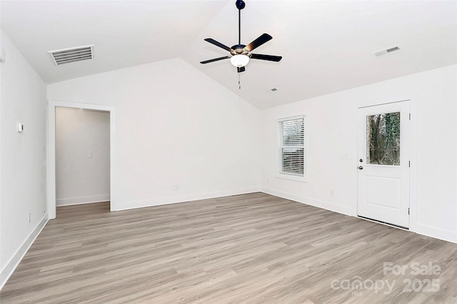 spare room with ceiling fan, lofted ceiling, and light wood-type flooring