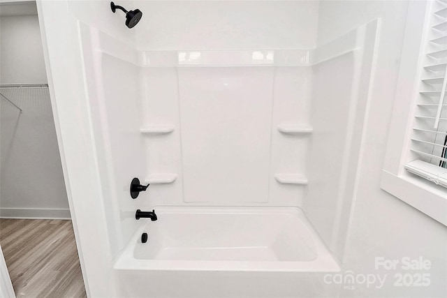 bathroom featuring shower / washtub combination and wood-type flooring