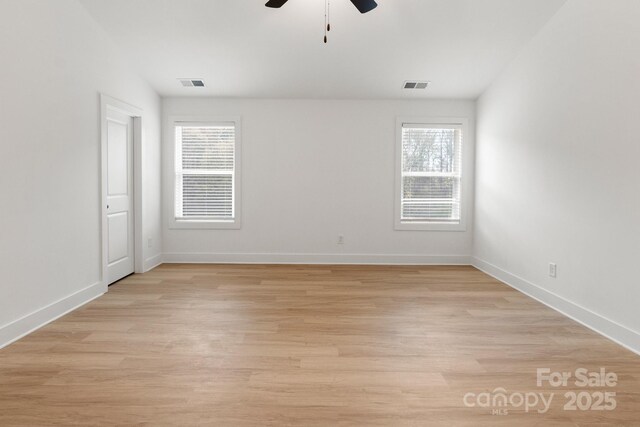 spare room featuring a wealth of natural light, light hardwood / wood-style floors, and ceiling fan