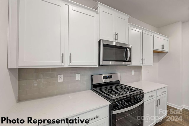 kitchen featuring appliances with stainless steel finishes, white cabinets, dark hardwood / wood-style floors, light stone counters, and tasteful backsplash