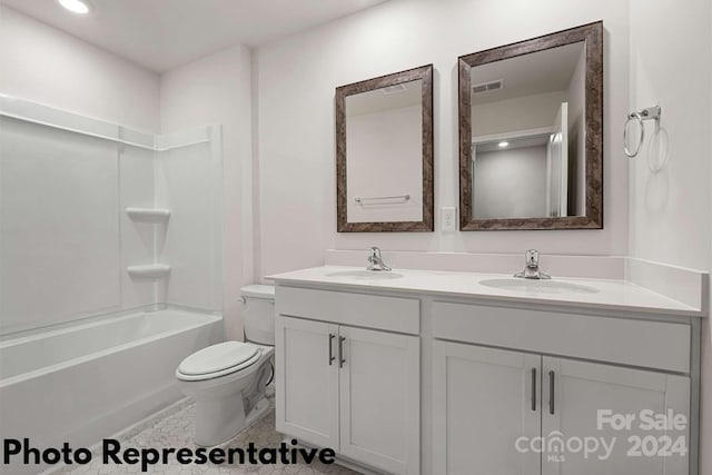 full bathroom with double sink, vanity with extensive cabinet space, washtub / shower combination, tile floors, and toilet