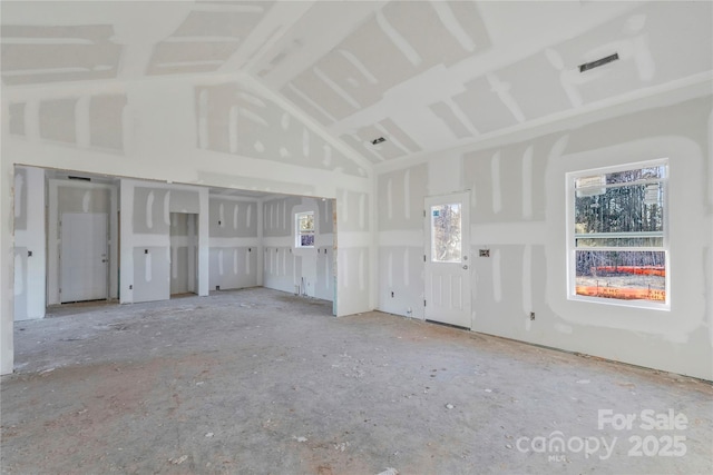 unfurnished living room featuring high vaulted ceiling