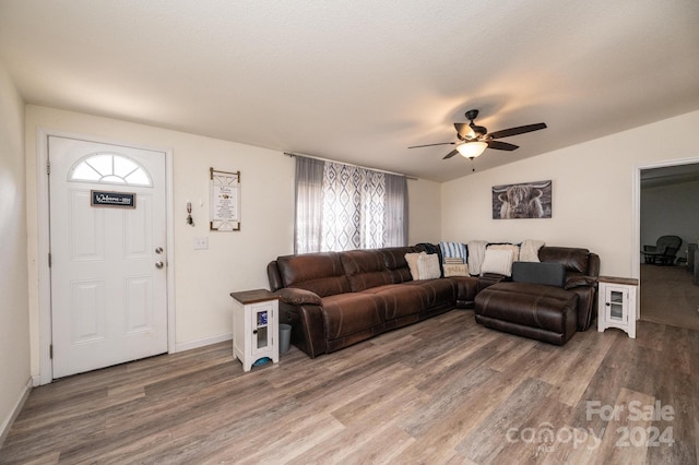 living room featuring ceiling fan, vaulted ceiling, a textured ceiling, and hardwood / wood-style floors