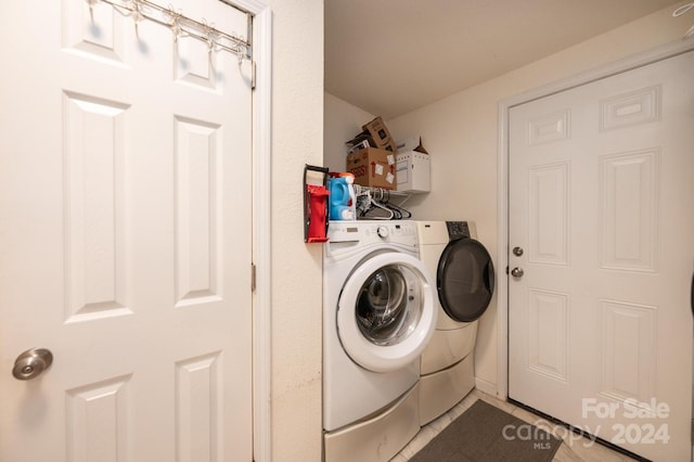 clothes washing area with light tile patterned floors and washing machine and clothes dryer