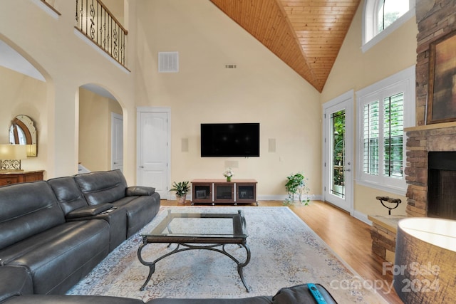 living room featuring wooden ceiling, high vaulted ceiling, hardwood / wood-style floors, and a fireplace