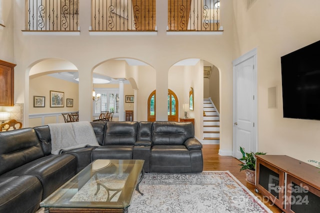 living room featuring an inviting chandelier, a high ceiling, and hardwood / wood-style flooring