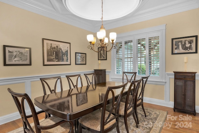 dining room featuring light hardwood / wood-style floors, crown molding, and a chandelier