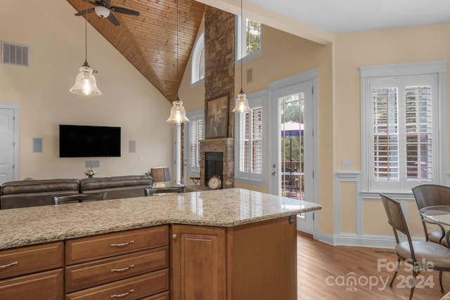 kitchen featuring a fireplace, light hardwood / wood-style flooring, wooden ceiling, high vaulted ceiling, and ceiling fan