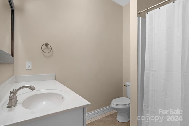 bathroom with tile flooring, vanity, and toilet