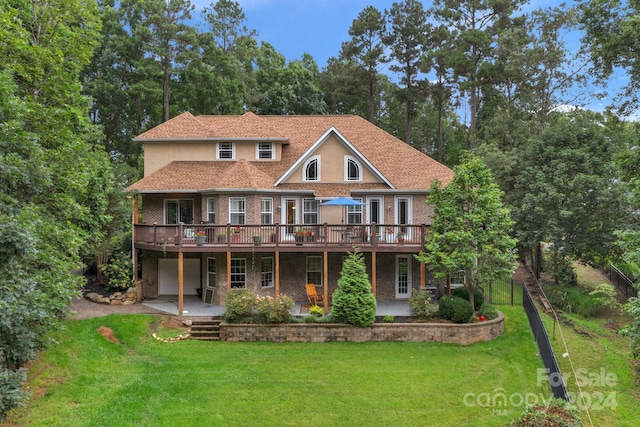 exterior space featuring a patio, a wooden deck, and a yard