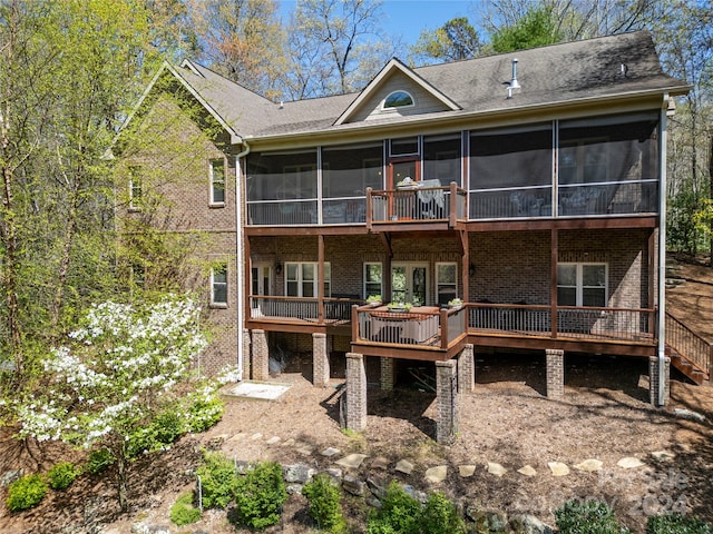 rear view of house featuring a sunroom and a wooden deck