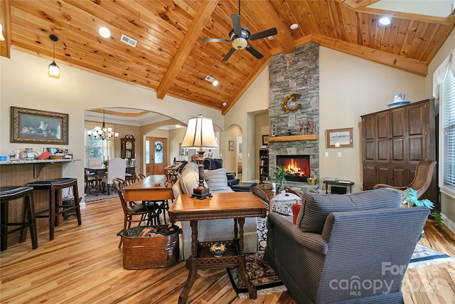 living room with light hardwood / wood-style floors, a fireplace, wood ceiling, ceiling fan with notable chandelier, and high vaulted ceiling