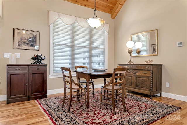 dining room featuring a healthy amount of sunlight, vaulted ceiling with beams, and hardwood / wood-style flooring