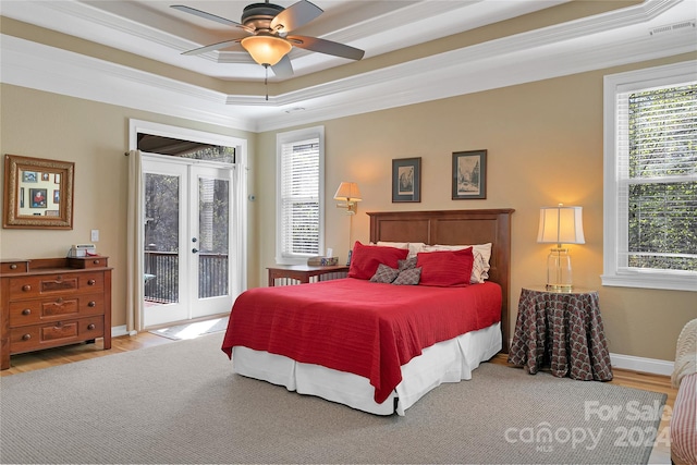 bedroom featuring ceiling fan, a tray ceiling, hardwood / wood-style flooring, and french doors