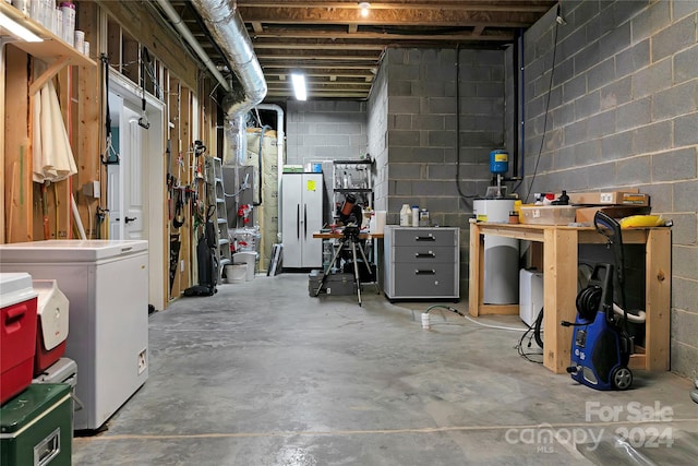 basement with water heater, a workshop area, and washer / dryer