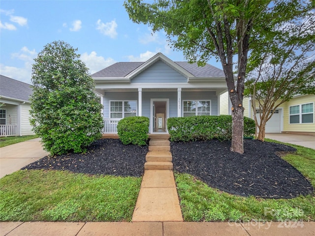 bungalow featuring a garage and a porch