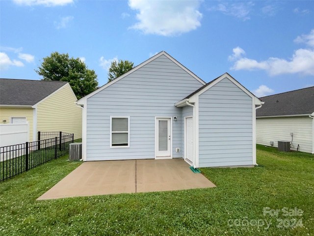 rear view of house featuring a lawn, central air condition unit, and a patio