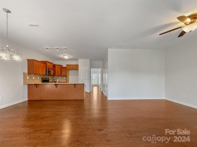 unfurnished living room with sink, hardwood / wood-style flooring, ceiling fan with notable chandelier, and rail lighting