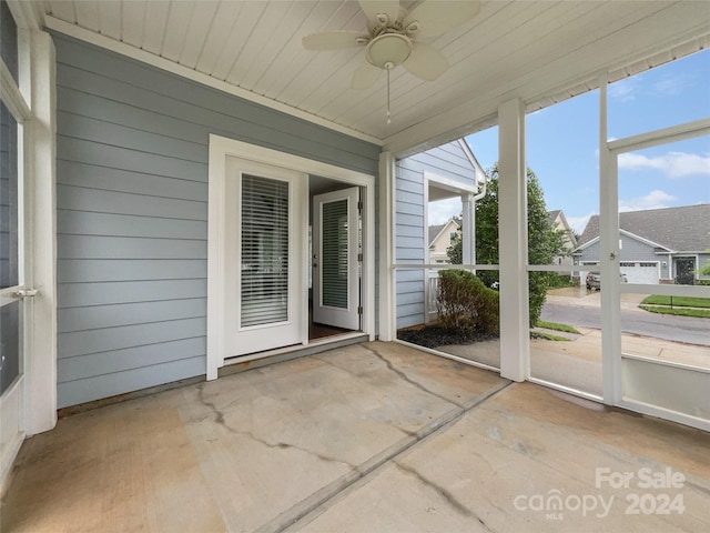 unfurnished sunroom with ceiling fan