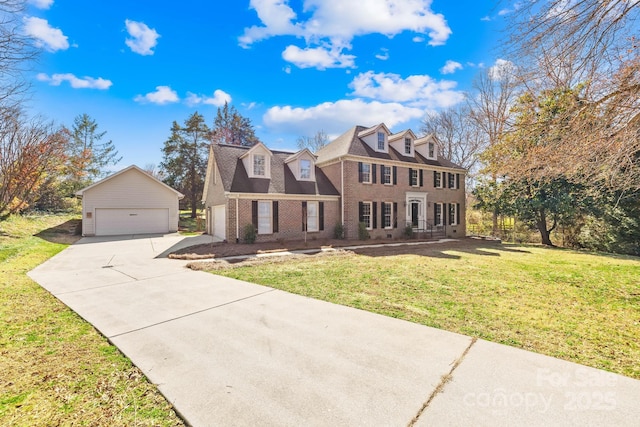 view of front of property with a garage, brick siding, an outdoor structure, and a front lawn