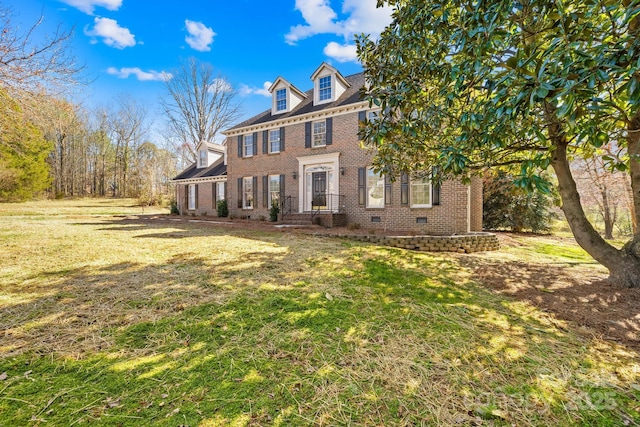 colonial house featuring a front yard, crawl space, and brick siding