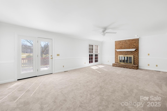 unfurnished living room featuring carpet, a fireplace, baseboards, and ceiling fan