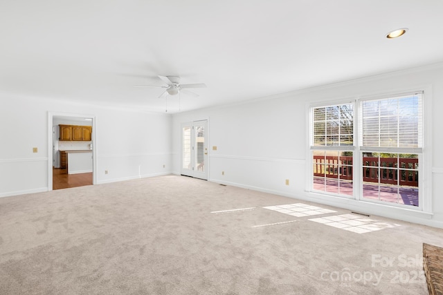 interior space featuring crown molding, baseboards, and a ceiling fan