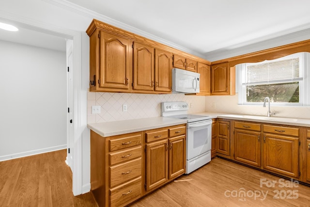 kitchen with white appliances, brown cabinets, light wood-style floors, and light countertops