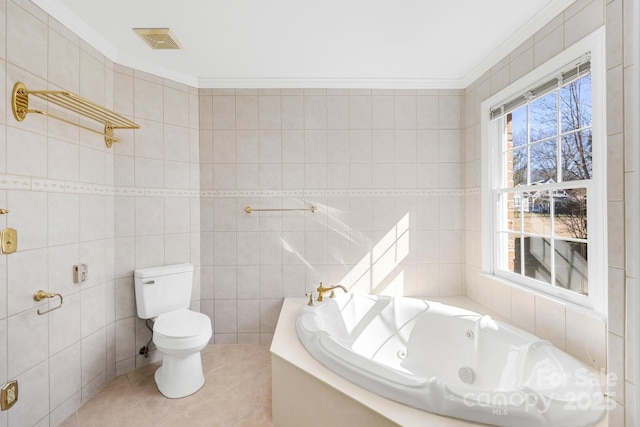 bathroom with visible vents, ornamental molding, tile patterned floors, a whirlpool tub, and tile walls