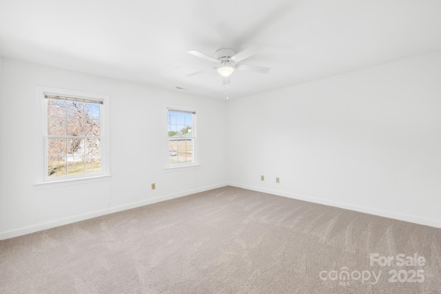 unfurnished room with carpet floors, baseboards, and a ceiling fan