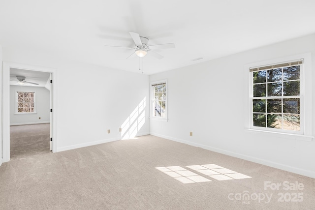 carpeted spare room with baseboards and a ceiling fan