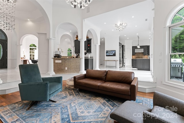 living room featuring a high ceiling, a notable chandelier, and wood-type flooring