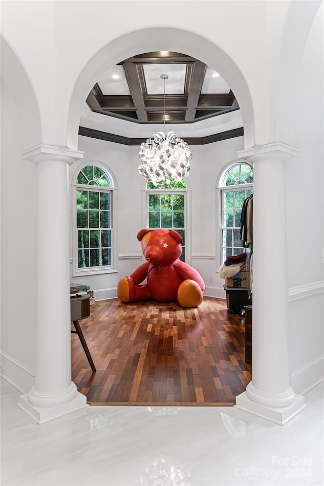 living area with a chandelier, beam ceiling, ornamental molding, and coffered ceiling