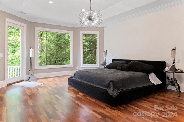 bedroom with hardwood / wood-style floors, an inviting chandelier, access to exterior, ornamental molding, and a tray ceiling